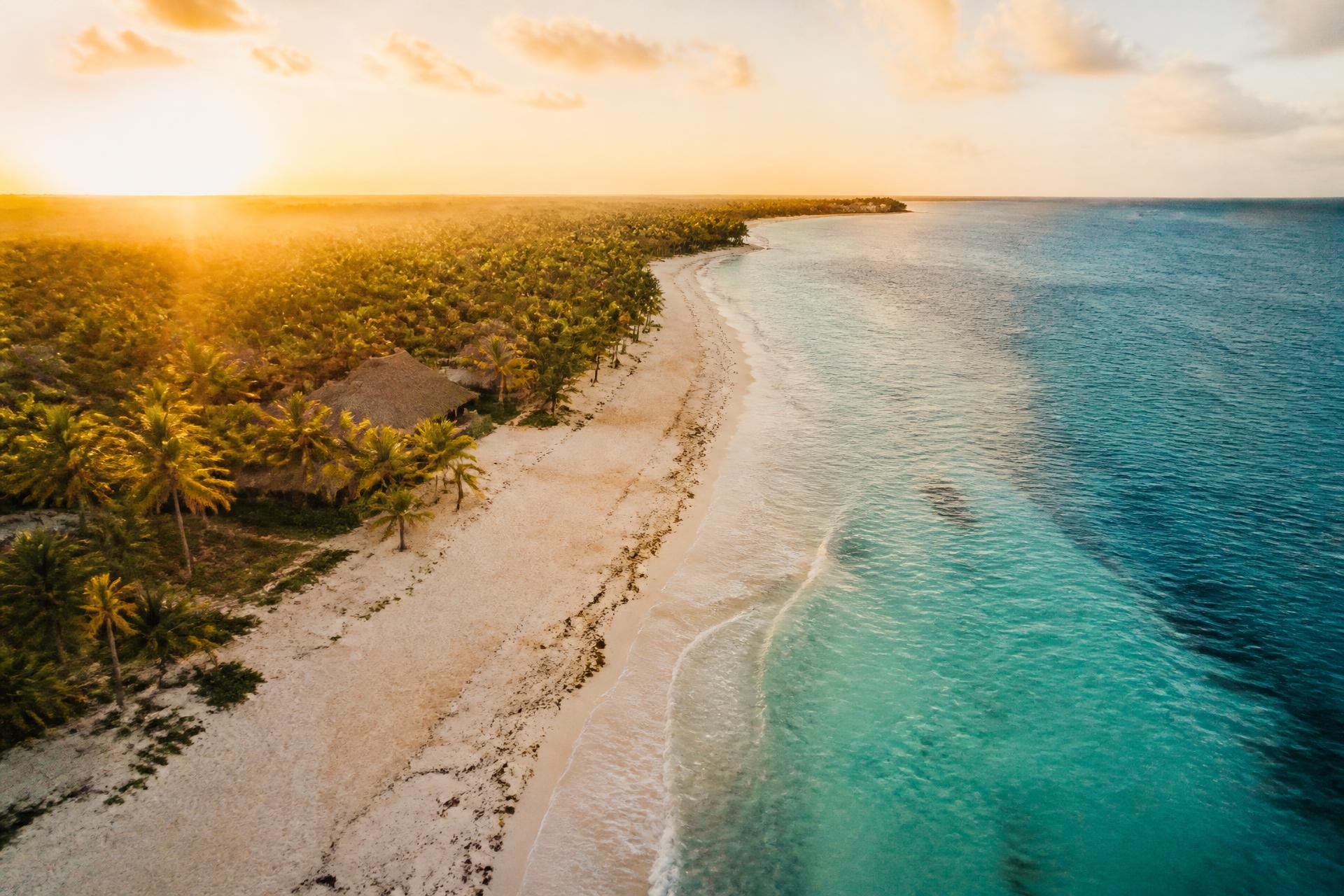 Riviera Maya coastline at golden hour, turquoise water meeting pale sand